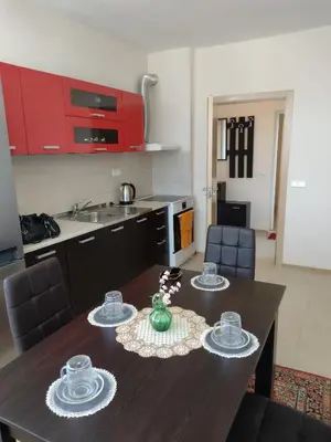 a kitchen with a wooden table with dishes on it at Ред хаус in Sunny Beach