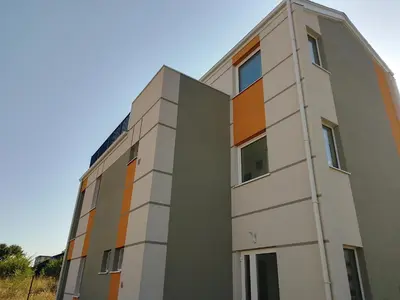 an apartment building with an orange and gray at July's Guest House in Primorsko