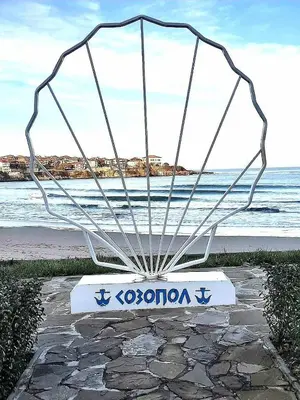 a metal bench sitting on top of a beach at Sea Time Sozopol in Sozopol