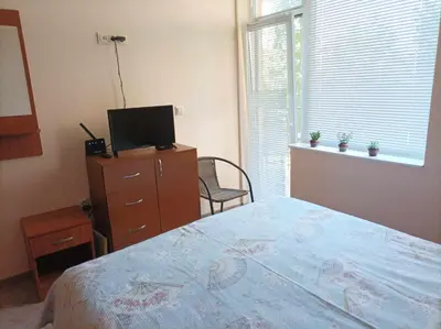 a bedroom with a bed and a dresser and a television at Sea Time Sozopol in Sozopol