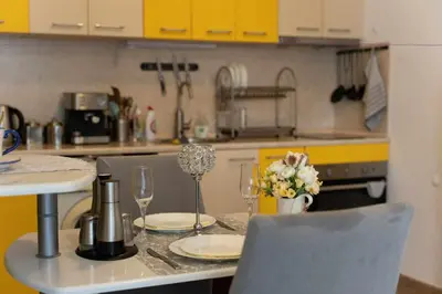 a kitchen with a table with glasses and flowers on it at Sea Time Sozopol in Sozopol