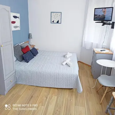 a small bedroom with a bed and a desk at Guest House Sunflowers in Pomorie