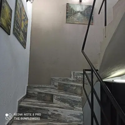 a staircase with wooden steps and paintings on the wall at Guest House Sunflowers in Pomorie