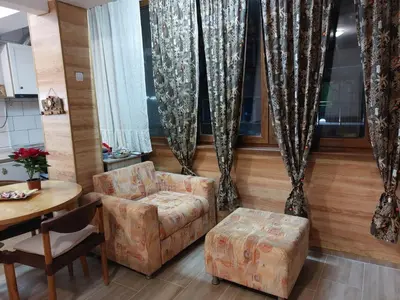 a living room with a chair and a table at Студио Тони in Burgas City