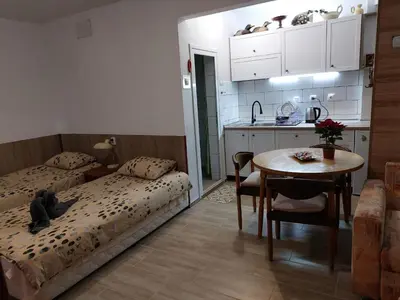 a room with two beds and a table and a kitchen at Студио Тони in Burgas City