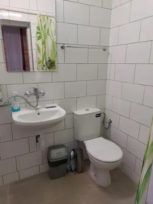 a white bathroom with a toilet and a sink at Студио Тони in Burgas City