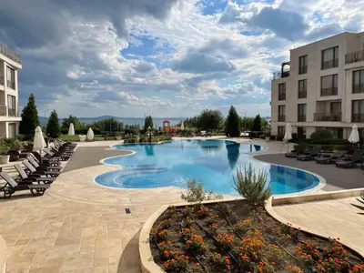 a pool at a hotel with chairs and a building at Diamond Beach Apartment 2 Room in Burgas City
