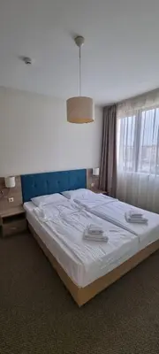 a bedroom with a large bed with white sheets at APART SUN Travel SUNNY BEACH in Sunny Beach