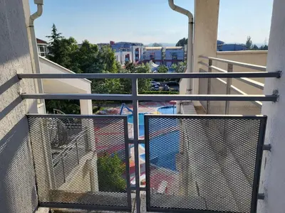 a balcony with a gate with a view of a pool at Complex ELIT Cacao Beach - Apartments for rent- ЕЛИТ Слънчев бряг in Sunny Beach