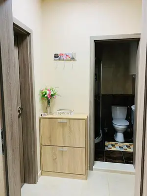 a bathroom with a toilet and a vase of flowers at Kiwi Gardens in Byala