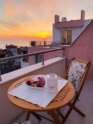 a table with a plate of food on a balcony at Kiwi Gardens in Byala