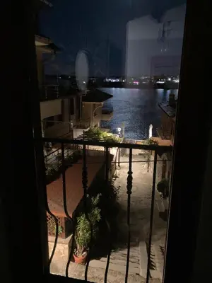 a view of the water from a balcony at night at GoodRest Sozopol in Sozopol