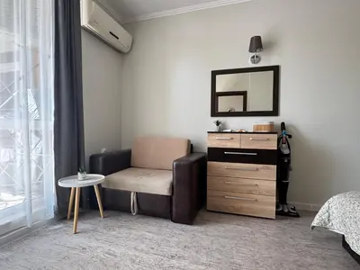 a bedroom with a chair and a dresser with a mirror at Apartment Nani -Sunny beach in Sunny Beach