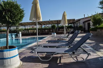 a row of lounge chairs and umbrellas next to a swimming pool at Sea View Sarafovo in Sarafovo
