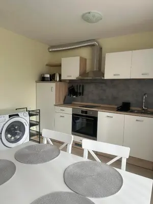 a kitchen with a table and chairs and a washing machine at Sea View Sarafovo in Sarafovo