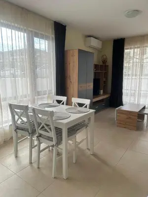 a white table and chairs in a room with windows at Sea View Sarafovo in Sarafovo