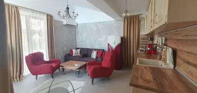 a living room with a couch and two red chairs at Апартамент Злато изглед МОРЕ in Sozopol
