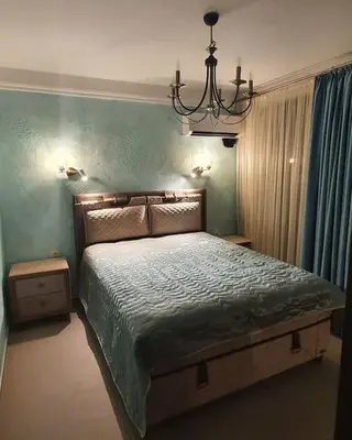 a bedroom with a bed and a chandelier at Апартамент Злато изглед МОРЕ in Sozopol