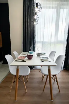 a white dining room table with white chairs and a chandelier at Sky Residence Burgas with FREE Garage - Sky Apartments Burgas in Burgas City