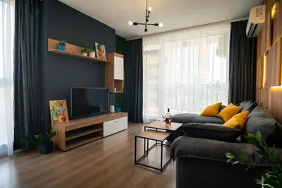 a living room with a couch and a television at Sky Residence Burgas with FREE Garage - Sky Apartments Burgas in Burgas City
