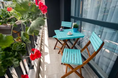 a blue table and chairs on a balcony with flowers at Sky Residence Burgas with FREE Garage - Sky Apartments Burgas in Burgas City
