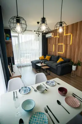 a living room with a table with dishes on it at Sky Residence Burgas with FREE Garage - Sky Apartments Burgas in Burgas City