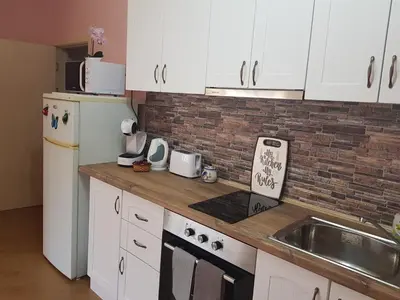 a kitchen with white appliances and a brick wall at Sarafovo Sea Paradise in Burgas City