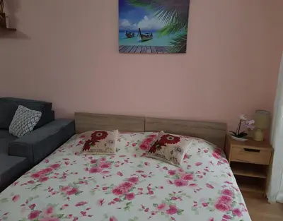 a bedroom with a bed with a floral bedspread at Sarafovo Sea Paradise in Burgas City