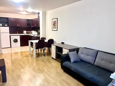 a living room with a couch and a table and a kitchen at Vadim Apartments in Panorama Beach Vigo Nessebar in Nesebar