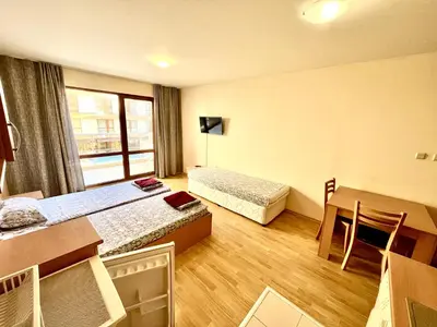 a hotel room with two beds and a table and a desk at Vadim Apartments in Panorama Beach Vigo Nessebar in Nesebar