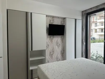 a bedroom with a bed and a tv on a wall at Сарафово Лукс Тераса Първа Линия in Sarafovo