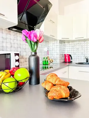 a kitchen counter with a vase of flowers and bread at Апартамент Каскадас В54 in Sunny Beach