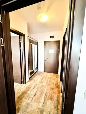 an empty hallway with wood floors and a door at Апартамент Каскадас В54 in Sunny Beach