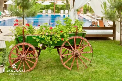 a cart filled with flowers and plants next to a pool at Студио Каскадас К34 in Sunny Beach
