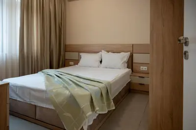 a bedroom with a bed with white sheets and pillows at Ваканционна Къща в Greenn Life Созопол in Sozopol
