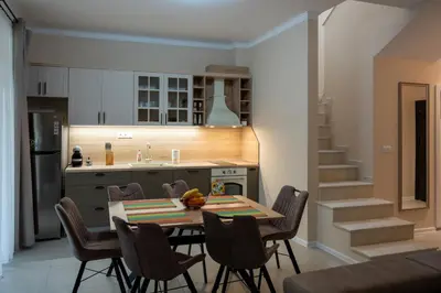 a kitchen and dining room with a table and chairs at Ваканционна Къща в Greenn Life Созопол in Sozopol