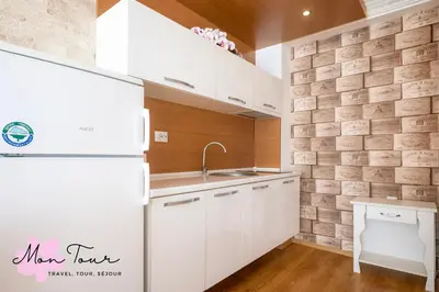 a kitchen with white cabinets and a refrigerator at Mon Tour apartments in Sunny Beach