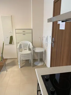 a kitchen with a white chair and a table at Premier Fort Beach ap. №376 section: E-3 in Sveti Vlas