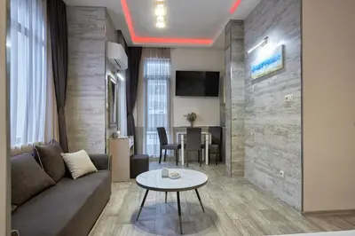 a living room with a couch and a table at Studio in Sarafovo with Private Parking Spot by Flat Mаnаger in Burgas City