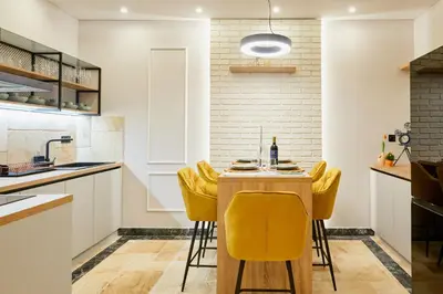 a kitchen with a table and yellow chairs at Florance Rentals Luxury Apartments in Burgas in Burgas City
