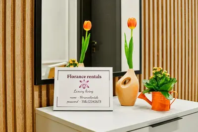 a sign on a table with flowers and a vase at Florance Rentals Luxury Apartments in Burgas in Burgas City