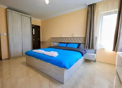 a bedroom with a blue bed with towels on it at Luxury Sea Villas - Kabalan in Burgas City