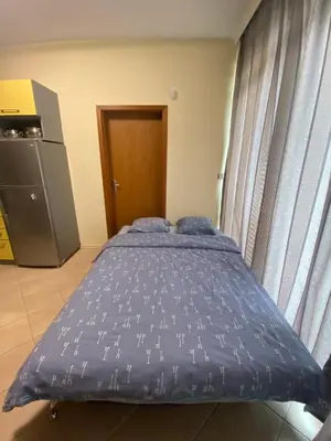 a bed with blue sheets in a small room at YS Residence in Sunny Beach