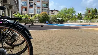 a bike parked in front of a swimming pool at Stamopolulux директен изглед към морето in Primorsko