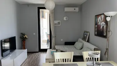 a living room with a couch and a table at Stamopolulux директен изглед към морето in Primorsko