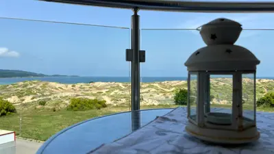 a window with a view of the desert and a lantern at Stamopolulux директен изглед към морето in Primorsko