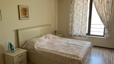 a small bedroom with a bed and a window at Stamopolulux директен изглед към морето in Primorsko