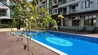 a swimming pool in front of a building at Stamopolulux директен изглед към морето in Primorsko