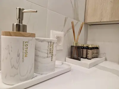 a counter with two rolls of toilet paper and a faucet at Apartment Marbél - Designer Retreat with FREE parking in Burgas City