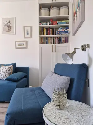 a living room with a blue couch and a table at Apartment Marbél - Designer Retreat with FREE parking in Burgas City